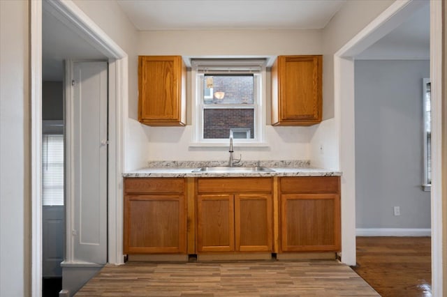 5534 Oldtown St, Detroit, MI 48224 - kitchen featuring a sink, light wood-style floors, and brown cabinetry