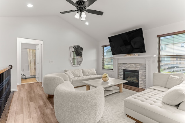 living room featuring ceiling fan, lofted ceiling, a wealth of natural light, and wood finished floors