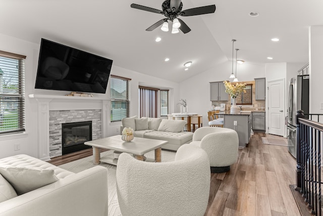 living room with ceiling fan, light wood-style flooring, and a wealth of natural light