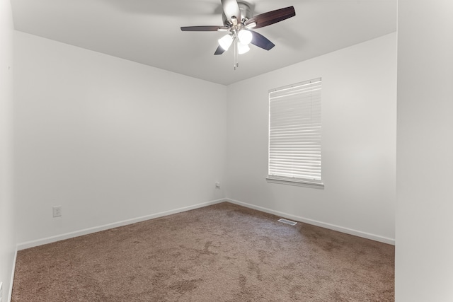 carpeted spare room featuring a ceiling fan, baseboards, and visible vents
