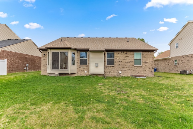 rear view of house featuring a yard, central air condition unit, and brick siding