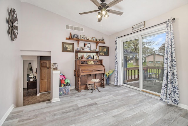 office space with a ceiling fan, baseboards, wood finished floors, lofted ceiling, and visible vents