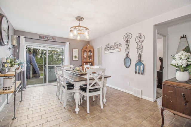 dining space featuring baseboards, a chandelier, and visible vents