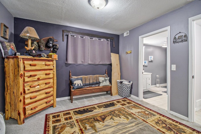interior space featuring visible vents, a textured ceiling, carpet, and baseboards