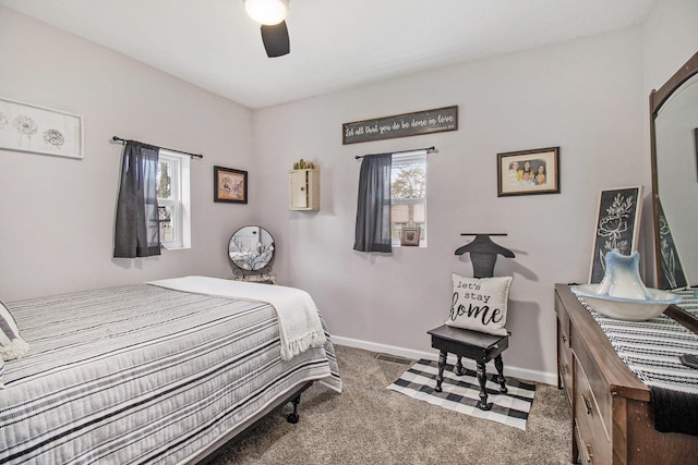 carpeted bedroom with baseboards, a ceiling fan, and visible vents