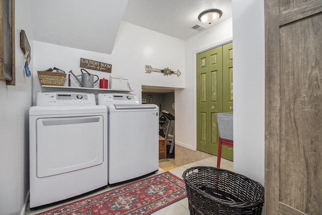 laundry room featuring separate washer and dryer, laundry area, visible vents, and light tile patterned floors