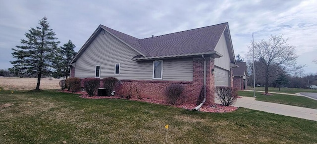 view of home's exterior with a yard, brick siding, and a garage