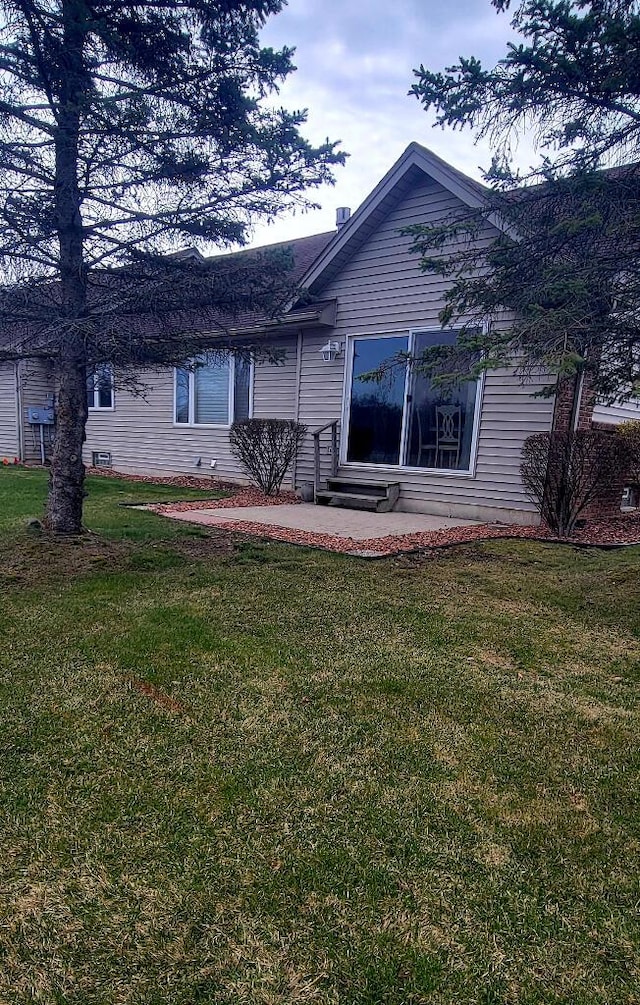 back of property with a yard and entry steps