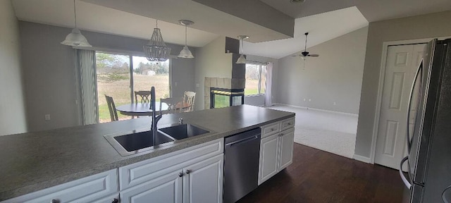 kitchen featuring white cabinets, dark wood-style flooring, ceiling fan with notable chandelier, stainless steel appliances, and lofted ceiling