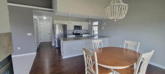 dining room featuring dark wood-style flooring, baseboards, an inviting chandelier, and a high ceiling