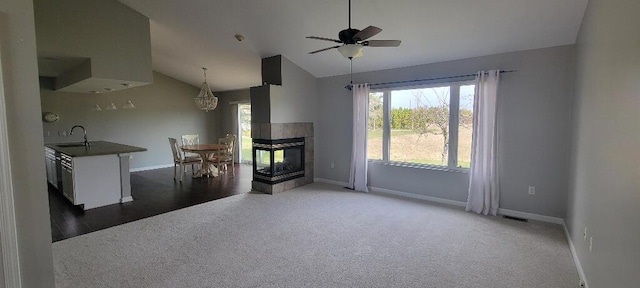 unfurnished living room with a sink, visible vents, carpet floors, baseboards, and vaulted ceiling