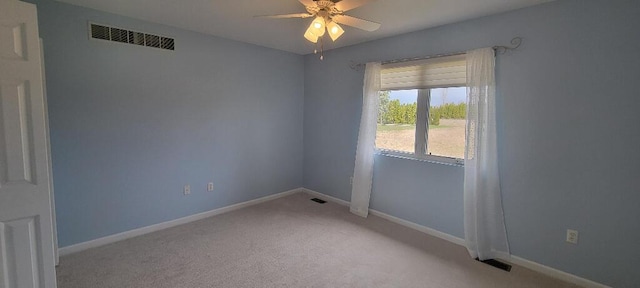 unfurnished room featuring baseboards, light carpet, a ceiling fan, and visible vents