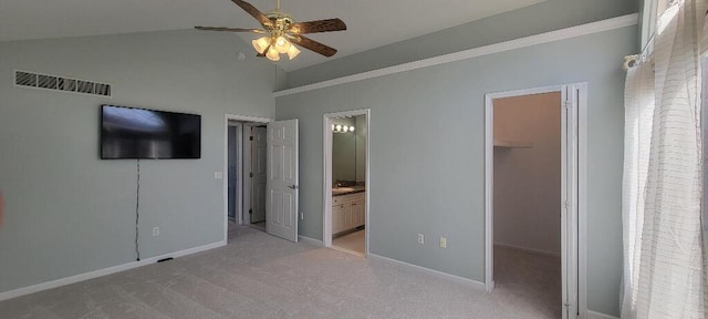 unfurnished bedroom with light colored carpet, baseboards, visible vents, and a walk in closet