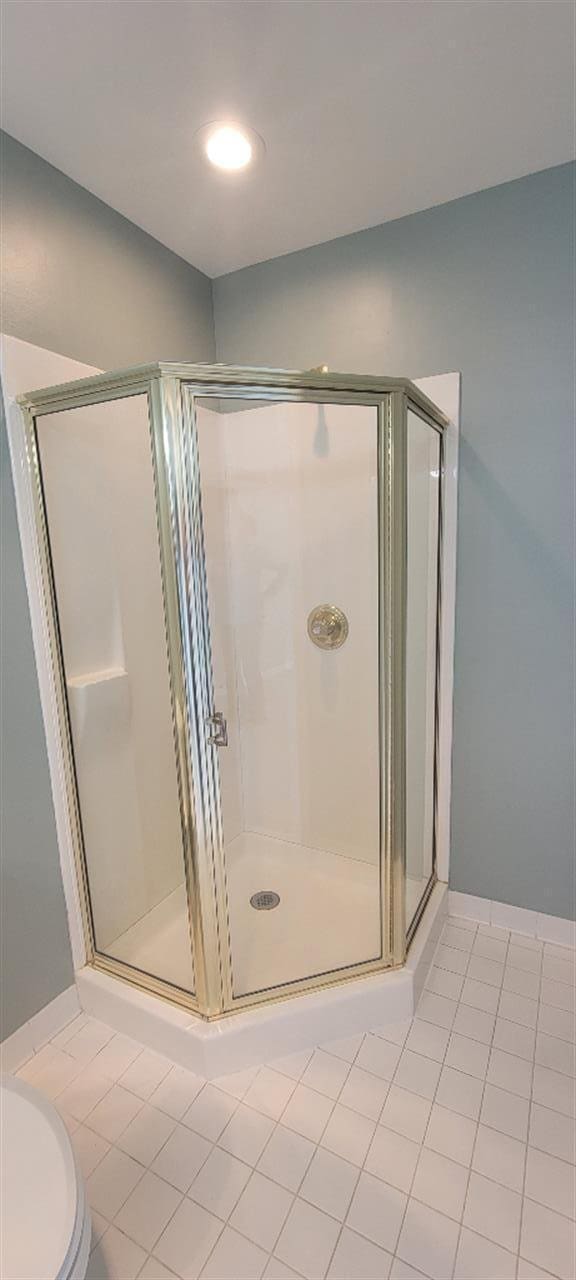 full bathroom with tile patterned flooring, toilet, and a shower stall