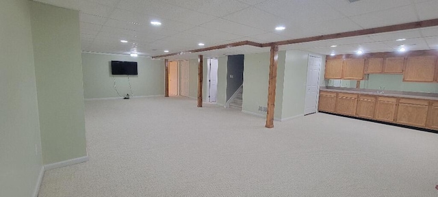 finished basement featuring light colored carpet, stairs, recessed lighting, baseboards, and a drop ceiling