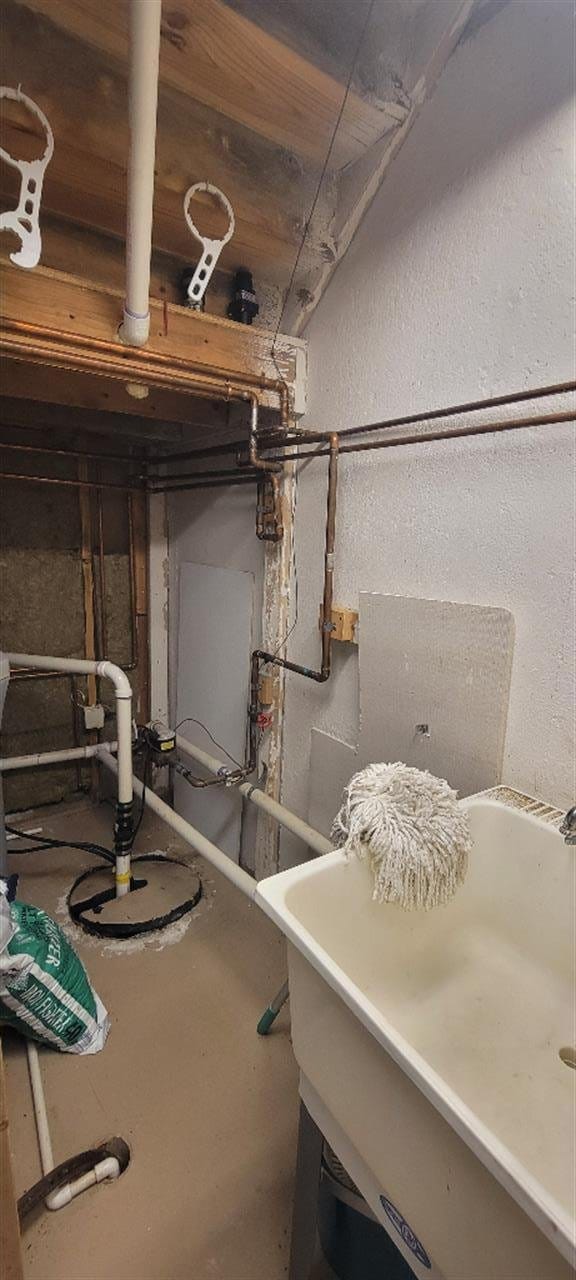 unfinished basement featuring a sink and a textured wall