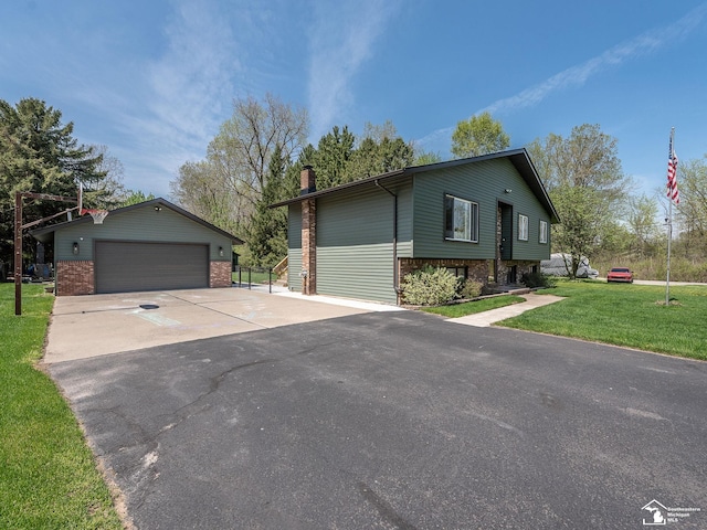 split foyer home with a detached garage, an outdoor structure, a chimney, and a front lawn