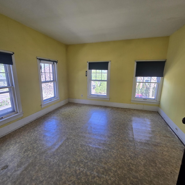 spare room featuring baseboards and plenty of natural light