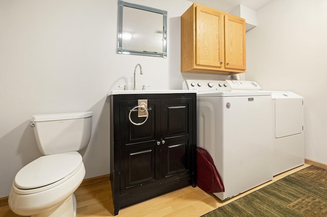 laundry area featuring a sink, laundry area, washing machine and dryer, and light wood finished floors