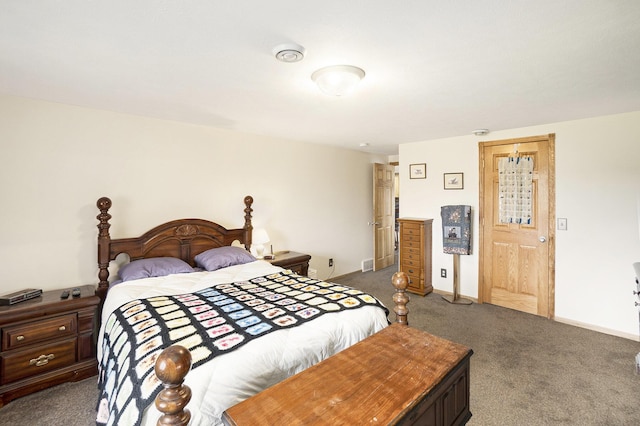 bedroom featuring baseboards and dark carpet