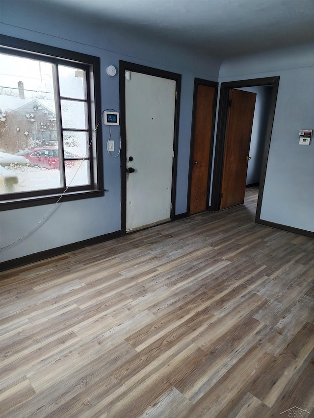 foyer entrance featuring baseboards and wood finished floors