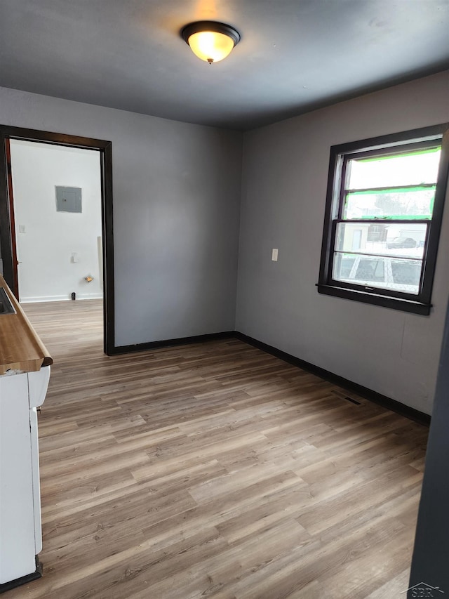 unfurnished room featuring baseboards and light wood-type flooring