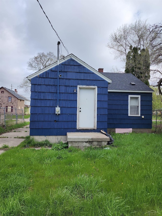 rear view of house featuring fence and a chimney