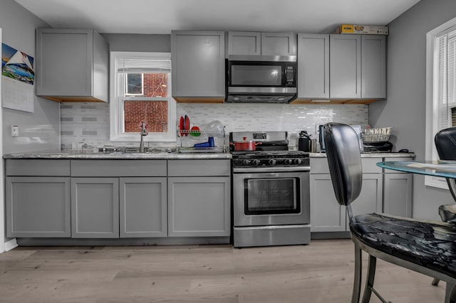 19631 Dwyer St, Detroit, MI 48234 - kitchen featuring backsplash, stainless steel appliances, gray cabinetry, and a sink