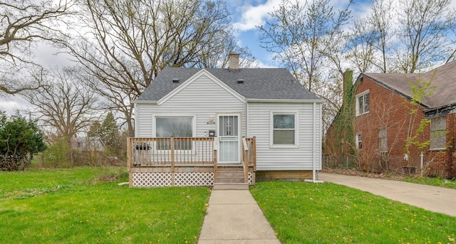 19631 Dwyer St, Detroit, MI 48234 - view of front of home featuring a deck, a chimney, roof with shingles, and a front lawn