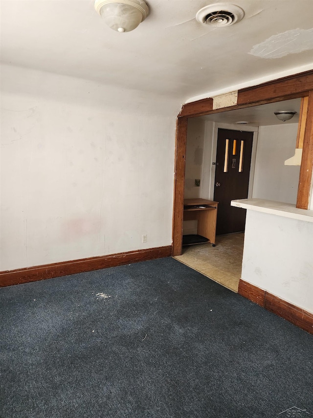 spare room with carpet floors, baseboards, and visible vents