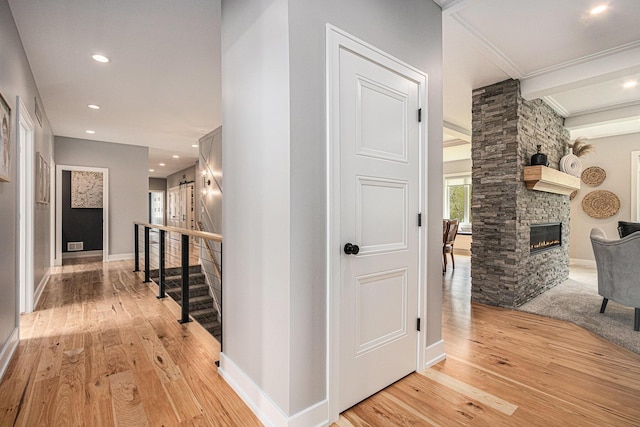 corridor with light wood-style flooring, recessed lighting, baseboards, ornamental molding, and stairway