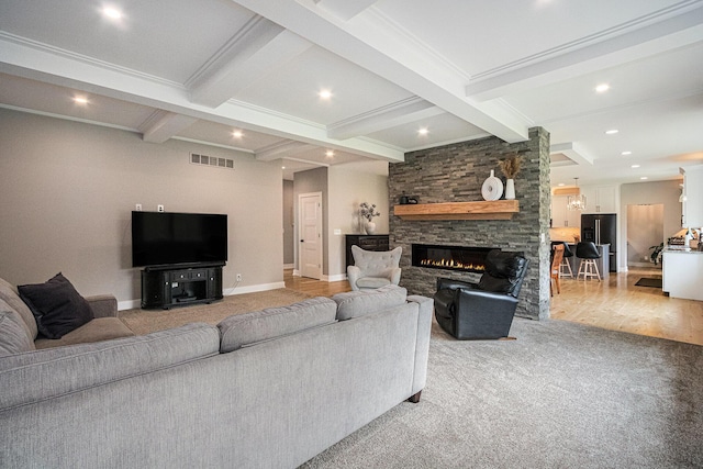 living area featuring beamed ceiling, light colored carpet, visible vents, and a fireplace