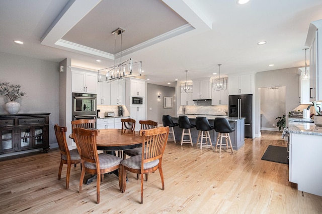 dining area featuring an inviting chandelier, a tray ceiling, and recessed lighting
