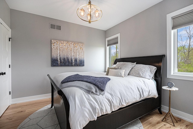bedroom with visible vents, light wood finished floors, and multiple windows