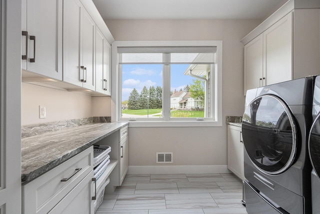 clothes washing area with cabinet space, washing machine and clothes dryer, marble finish floor, baseboards, and visible vents
