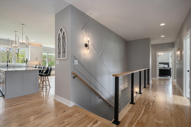 interior space featuring recessed lighting, baseboards, a sink, and light wood-style flooring