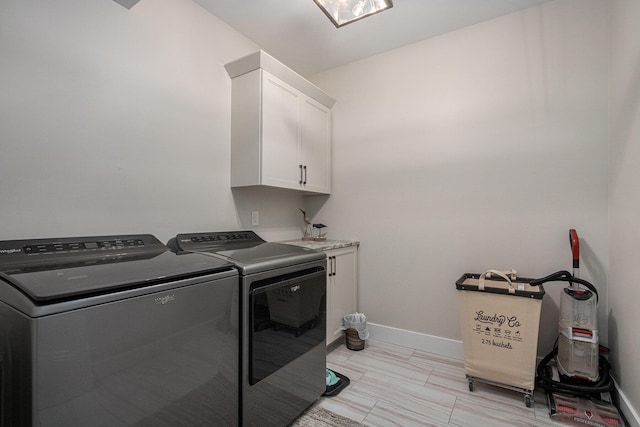 washroom with baseboards, washing machine and dryer, and cabinet space