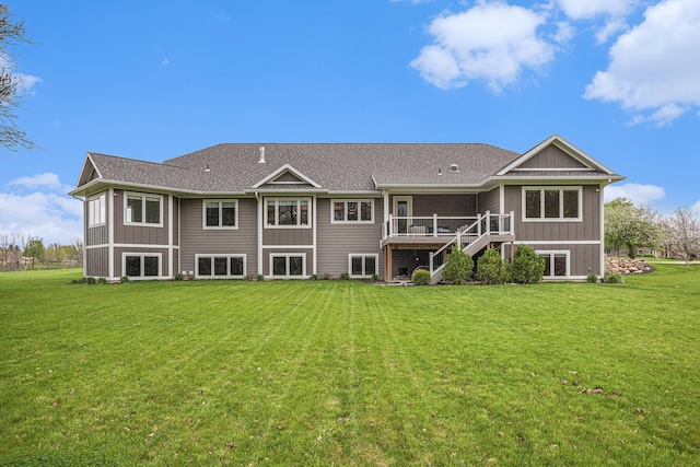 rear view of house featuring a wooden deck, a yard, and stairway