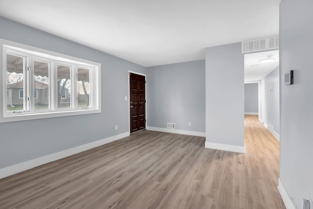 empty room with light wood-style flooring and baseboards
