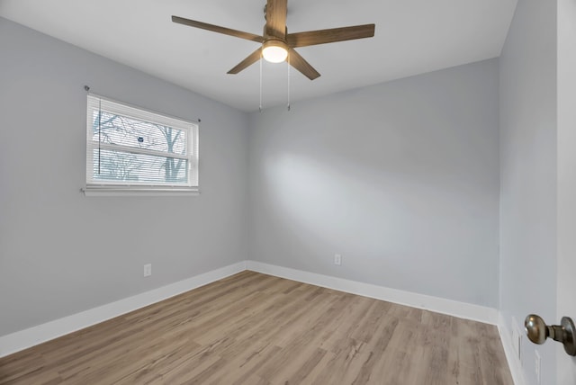 unfurnished room with baseboards, wood finished floors, and a ceiling fan