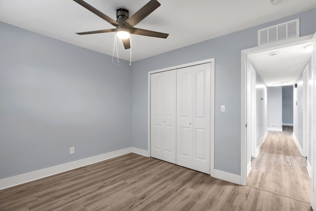 unfurnished bedroom featuring light wood-style flooring, baseboards, a closet, and ceiling fan