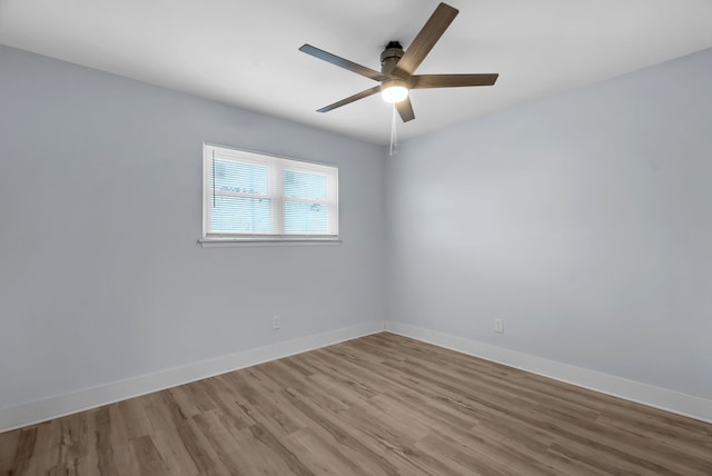 unfurnished room with ceiling fan, light wood-style floors, and baseboards