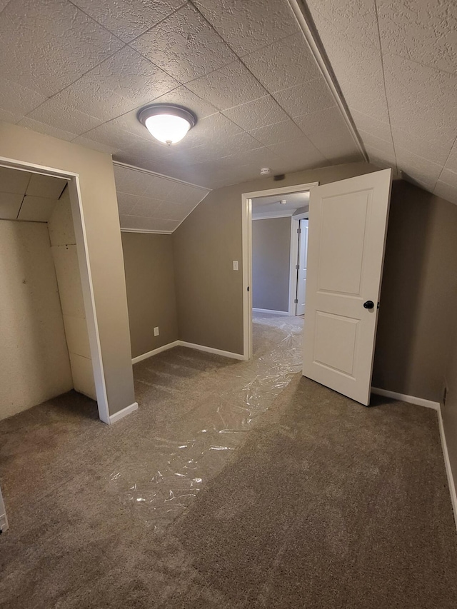 bonus room with carpet floors, baseboards, and vaulted ceiling