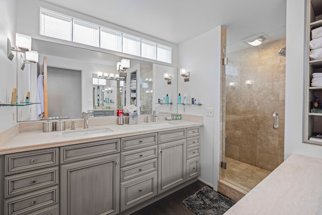 full bath featuring a stall shower, double vanity, a chandelier, and wood finished floors