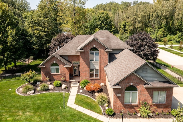 53345 Williams Way, Shelby Twp, MI 48316 - traditional-style house featuring fence, a front lawn, roof with shingles, and brick siding