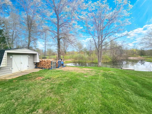 view of yard with a storage shed, a water view, and an outdoor structure