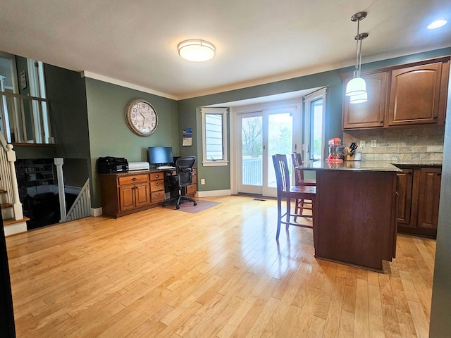 office area with ornamental molding, baseboards, and light wood-style flooring