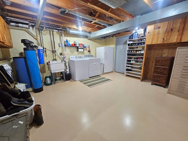 unfinished below grade area with freestanding refrigerator, washing machine and dryer, and a sink