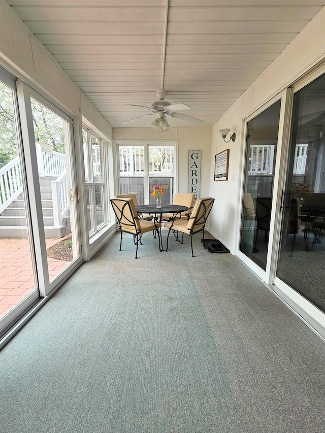 sunroom featuring plenty of natural light, outdoor dining space, and ceiling fan