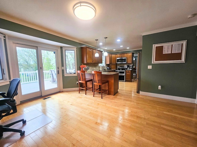 kitchen with a peninsula, stainless steel appliances, baseboards, and visible vents